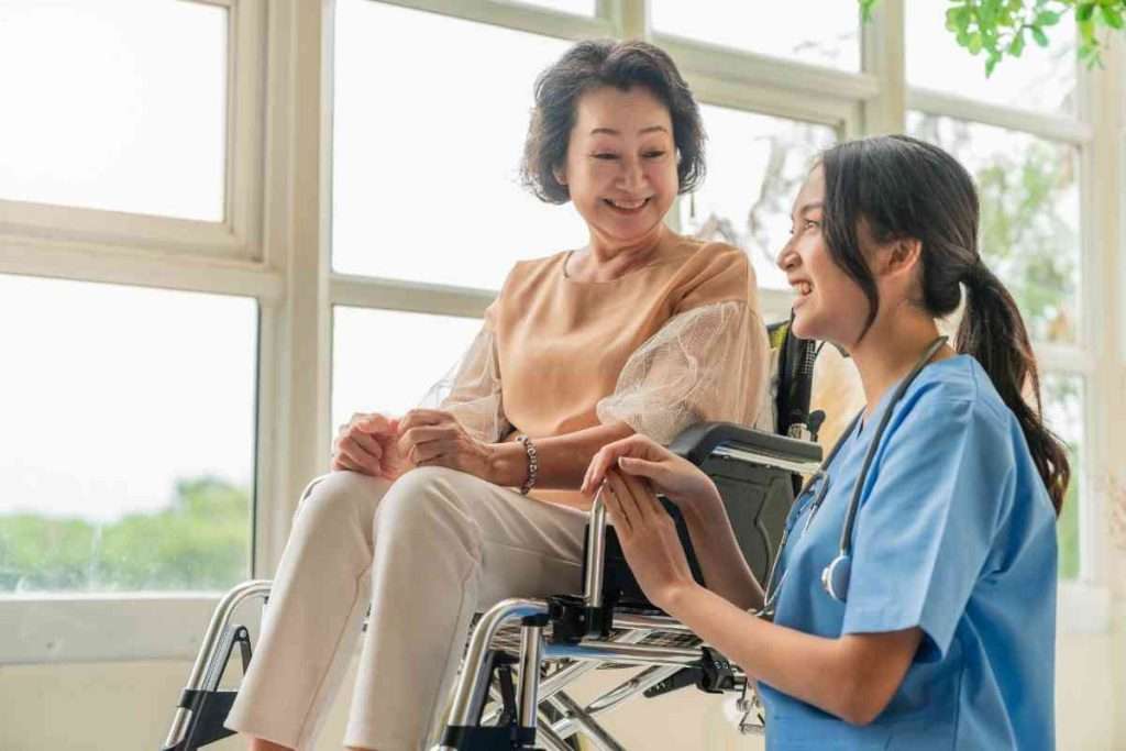 Caregiver holding hands and talking with a senior.