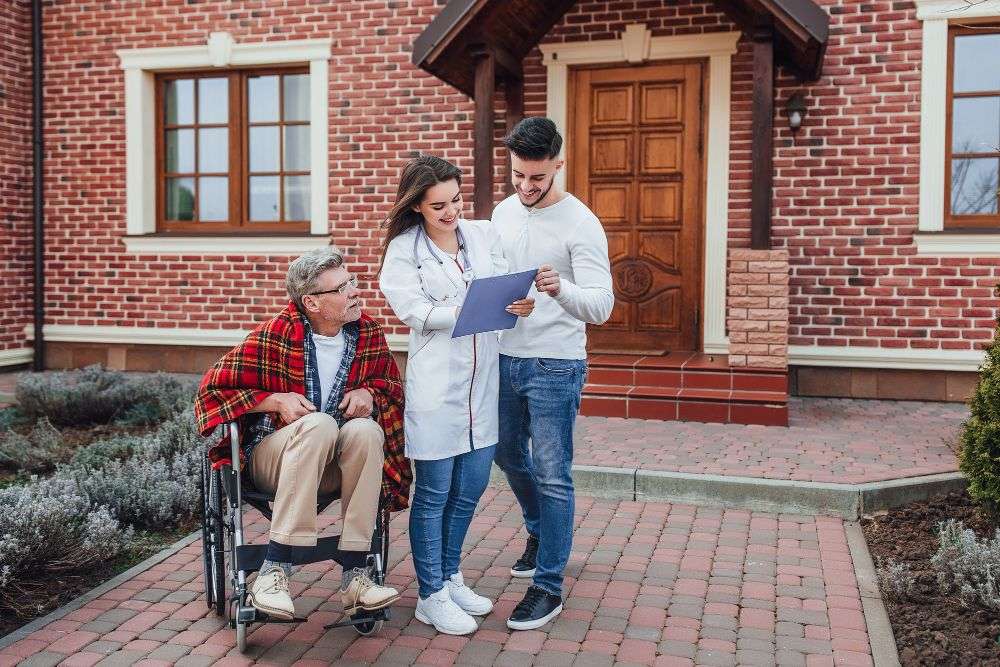 Professional caregiver assisting an elderly woman at home while discussing home care cost in Texas